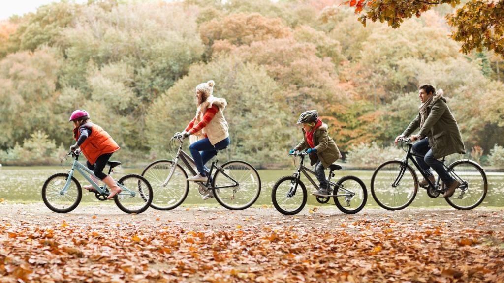семья едет по парку на велосипедах